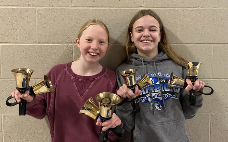two girls holding handbells